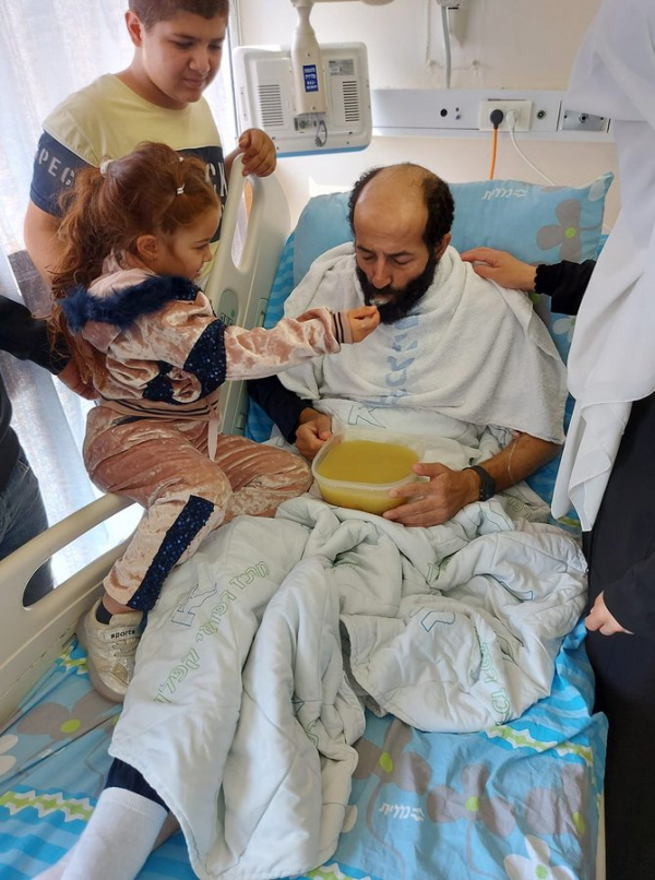 صورة الطفلة الفلسطينية وهي تطعم والدها الأسير بعد إضراب عن الطعام استمر 103 أيام